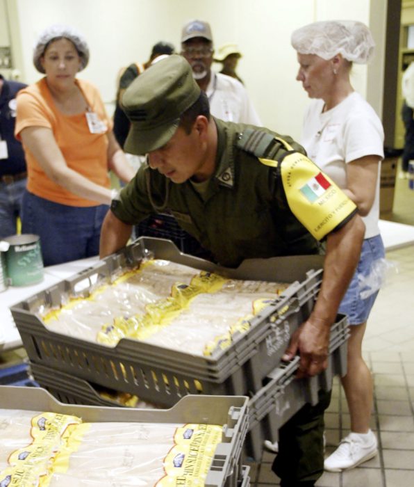 SAN ANTONIO - SEPTEMBER 9: A Mexican soldier moves loaves of bread in preparation for the noon meal for the evacuees located in San Antonio. The Mexican Army will be in San Antonio for 20 days to provide humanitarian relief. This is the first time the Mexican Army has been in San Antonio since 1846. (Photo by Joe Mitchell/Getty Images)